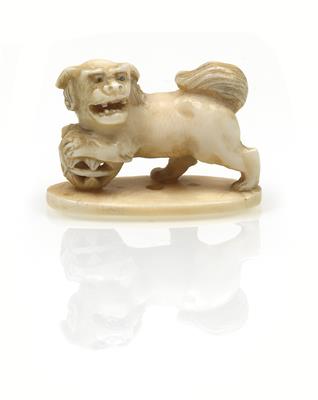 Netsuke des shishi mit beiden Vorderpranken auf einen Ball gestützt - Letní aukce