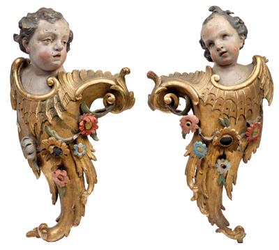A pair of large carved angels’ heads mounted on ornaments with floral garlands, - Oggetti d'arte