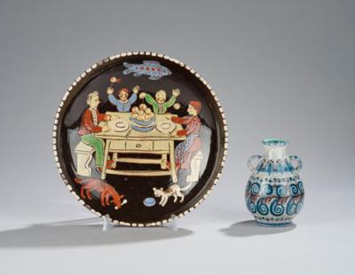 A wall plate depicting a family scene at the dinner table with a dog and a cat; including: a small handled jug, Schleiss, Gmunden - Secese a umění 20. století