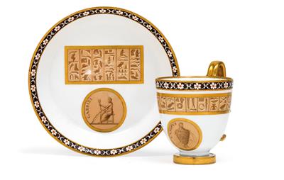 A cup and saucer with décor in the Egyptian manner, - Glass and porcelain