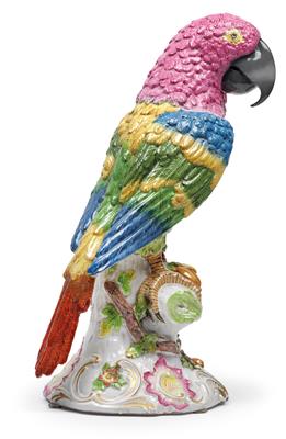 A figure of a parrot, perched on a tree trunk with leafy branches, - Glass and porcelain