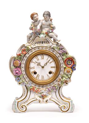 A porcelain clockcase with movement, with two amorettes, - Vetri e porcellane