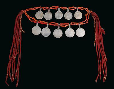 Morocco: a large necklace with 10 round spiral amulets made of silver, each strung on two double hanks with long pieces of red coral. Finished off at the sides with amber beads and red cotton strings. - Mimoevropské a domorodé umění