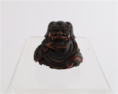 Netsuke eines Sitzenden mit Löwenmaske, - Starožitnosti